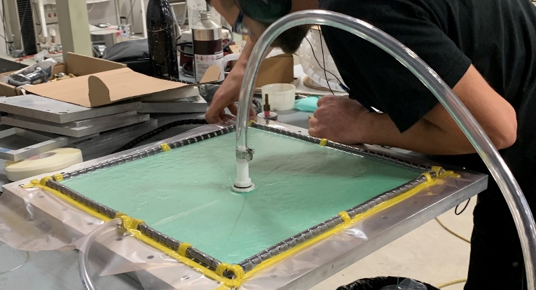 Vacuum infusion consists of laying dry fabrics in an open mold. The material is then covered with release film, breather material and a vacuum bag which is sealed around the perimeter of the mold. A vacuum is then between the open mold and the bag where resin is infused at a location where the resin will be able to seep through the fabrics throughout the part.